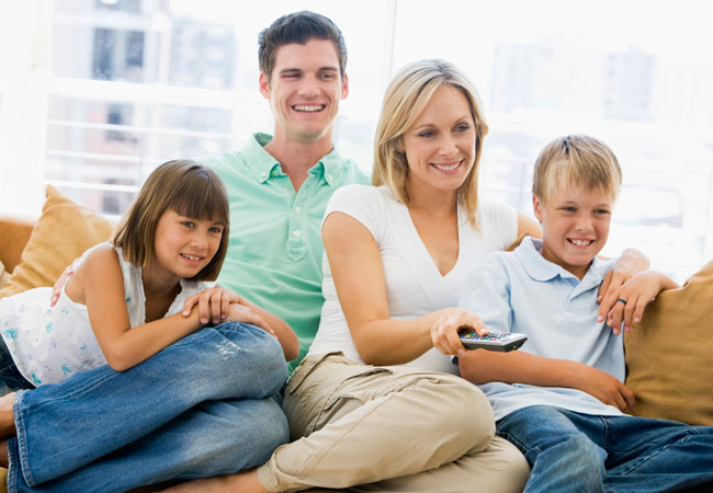 A family relaxing together on the sofa at home